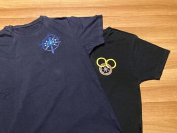 Twee donkere T-shirts met logo's uit fantasy boeken.